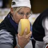 Un membre du jury en train de humer un fromage dans le cadre d'un concours.